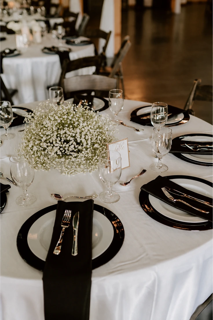 Black-and-white place settings on white tablecloths, from our wedding inspiration